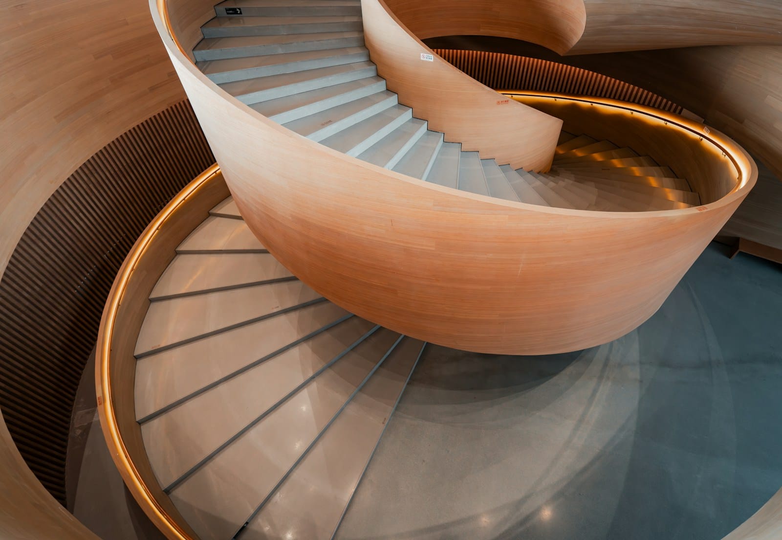 Modern spiral staircase with wooden accents and metallic railing.
